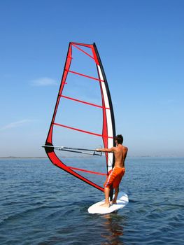 Windsurfer on waves of a gulf in the afternoon