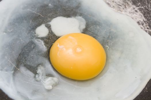 cooking the egg in the frying pan close-up