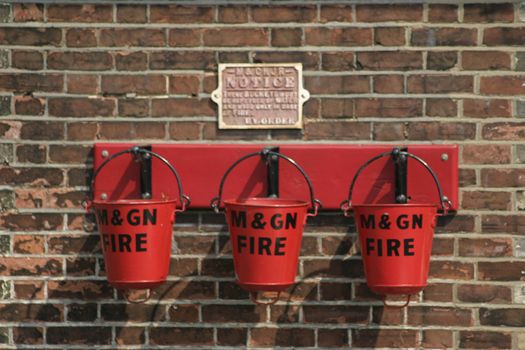 three fire buckets mounted on a wall