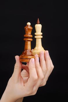 Two hands with black and white chesspieces