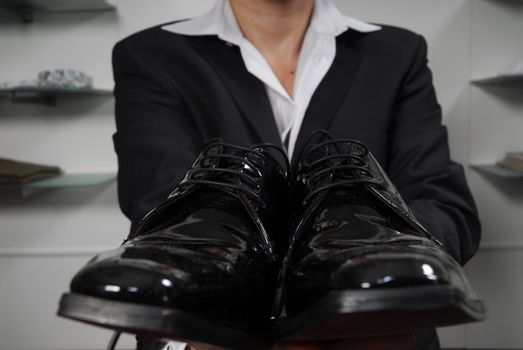 Man in business suit with varnished shoes in his hands