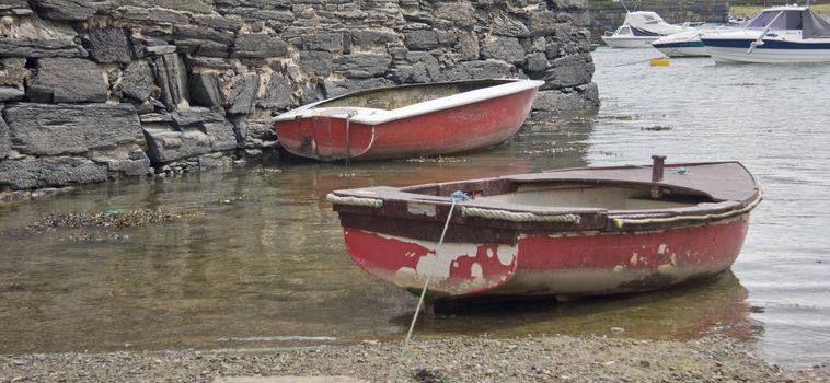 Two rowing boats moored at low tide.