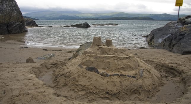 Sandcastle build at edge of dangerous estuary.