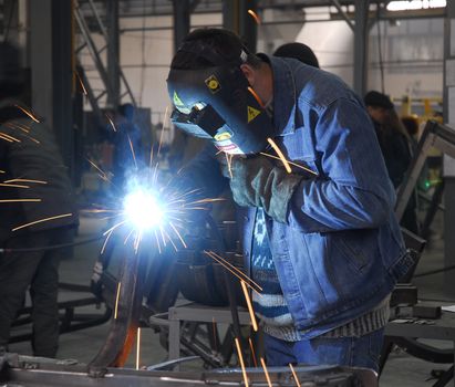 welding operator holding his mask