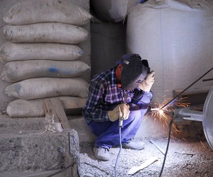 Welding operator on the floor and sparks 2