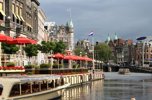 Tour boats in a canal outside a restaurant in Amsterdam
