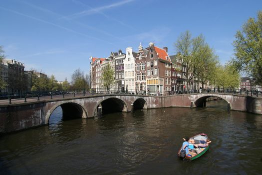 Man and woman boating in an Amsterdam canal