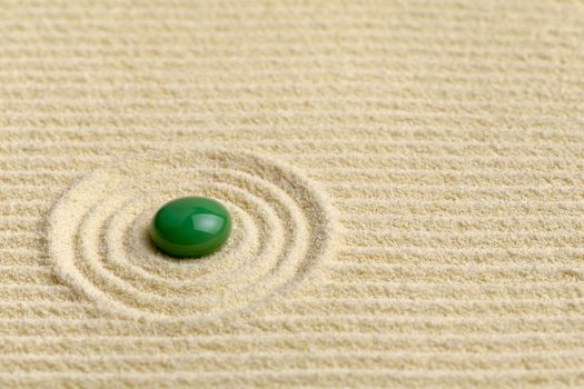 Artistic composition with green drop on the surface of the sand