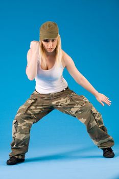 Attractive blond girl is dancing on a blue background