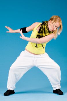 Attractive blond girl is dancing on a blue background