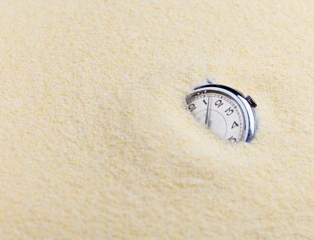 Composition on Zen garden - yellow sand, and old watch