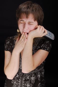 Young woman with tv remote control , isolated on black background