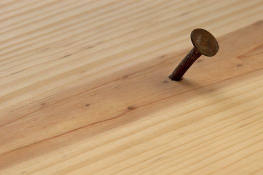 rusty nail in wood plank with grain texture