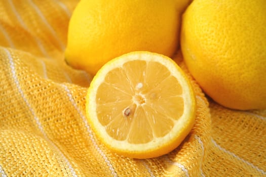 Fresh cut lemon on a yellow and white striped dish towel.