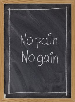 no pain, no gain - exercise, fitness, or coaching motto handwritten with white chalk on blackboard with eraser texture