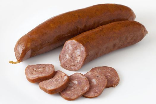 lean buffalo (bison) bratwurst cut and sliced on white background