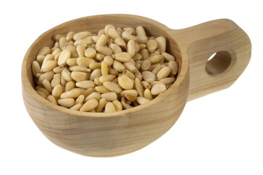 pine nuts on a rustic wooden bowl (scoop) isolated on white