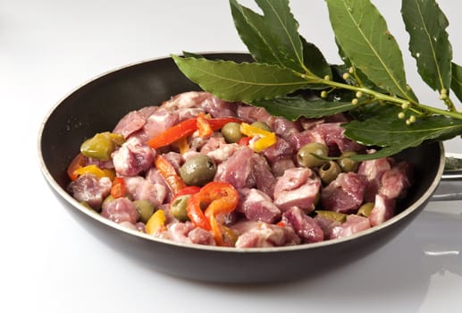 Pieces of pork with olives and peppers