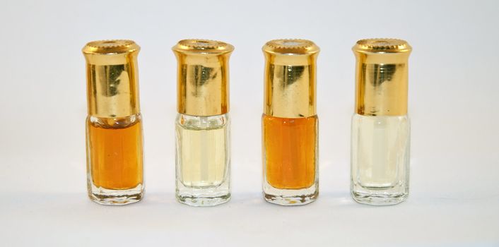 four small bottles of perfume on a white background