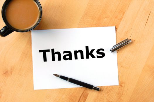 thanks or thank you concept with pen paper and coffee in office