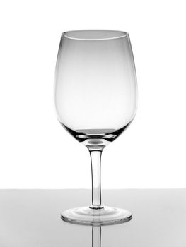 A shot of an empty glass wine with reflection on white background.