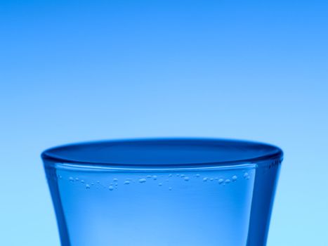 A shot of vodka on blue background.