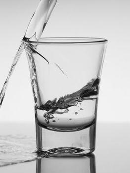 Pouring a shot of vodka. A conceptual image about the risk of  drinking excessively.