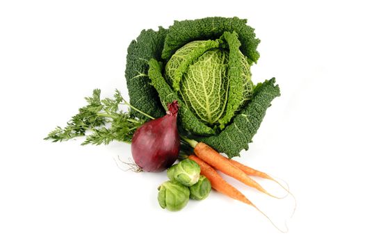 Single green raw cabbage with a single red onion, green sprouts and carrots on a reflective white background