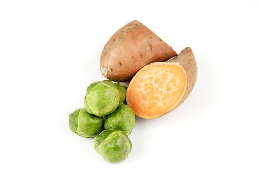 Sweet Potato cut in half with pile of green sprouts on a reflective white background