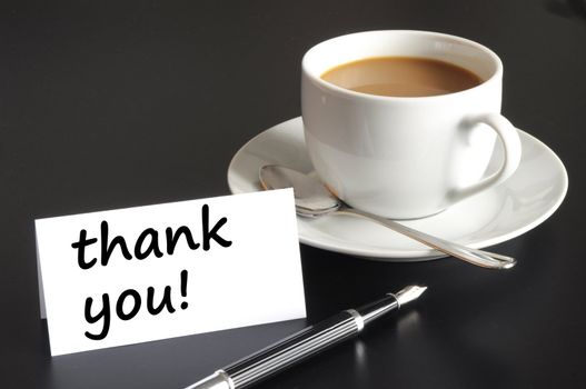 thank you or thanks concept with cup of coffee on black background