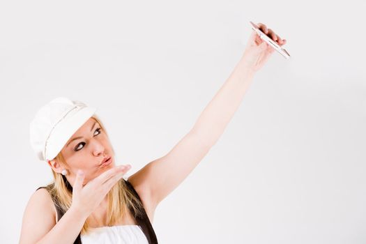 Young blond girl is busy with her cell phone