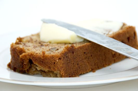 A slice of banana bread with butter.
