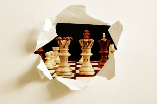 chess pieces behind hole in blank paper