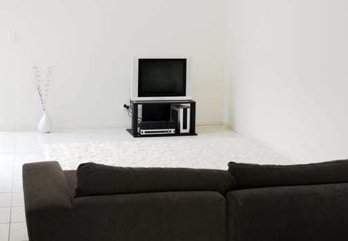 TV In Modern Living Room - White Tiles, Rug, Dark Sofa