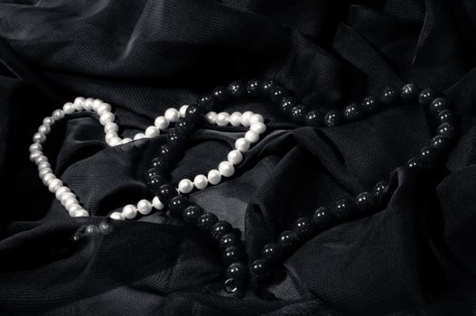 Heart from Pearl's necklace on dark cloth