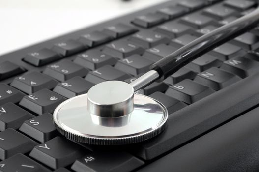stethoscope on computer keyboard showing medical or pc support concept
