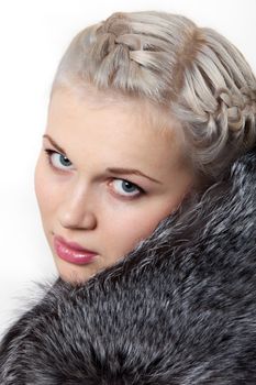 Portrait young beautiful girl in fur coat on white background