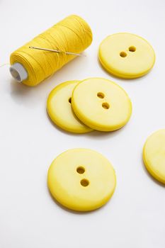 Some yellow big buttons and thread