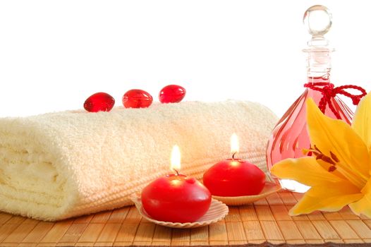 spa decoration with candles and red bottle with massage oil