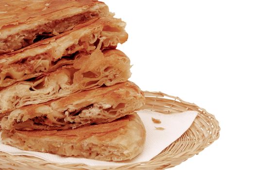 round burek slices in the basket close-up isolated over white background