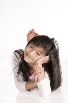 Little girl thinking with head off to side, lying on floor