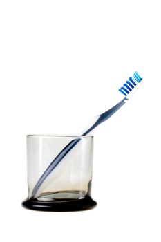 Transparent glass with one tooth-brush on a white background.