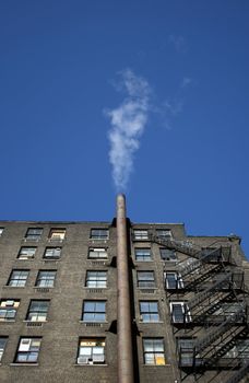 Smoking house. Smoke going out of the chimney of a brick house.