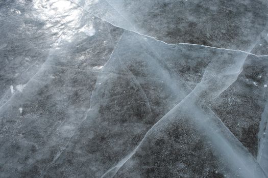 Cracked ice. Surface of a frozen river reflects the sun.