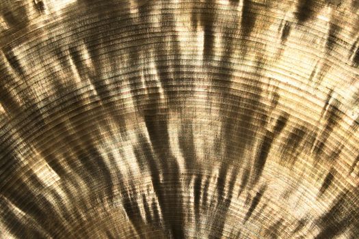 Shiny golden metallic texture of a cymbal under the sun.