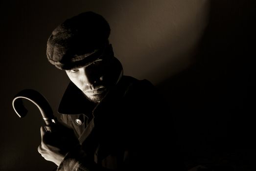 Sepia toned noir portrait of suspicious looking young man. Harsh highlights and shadows.