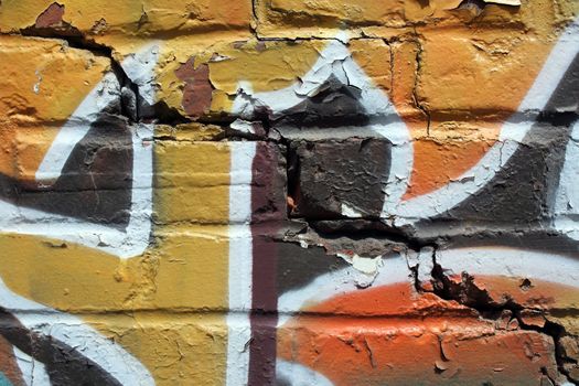 Grunge background. Bright colorful graffiti on a cracked brick wall.