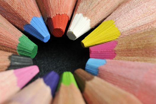 Colored pencils in star shape against black background