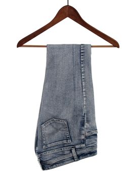Blue jeans on a wooden hanger, isolated on white background.