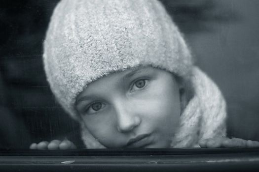 The nice girl behind glass of the automobile. b/w+blue tone